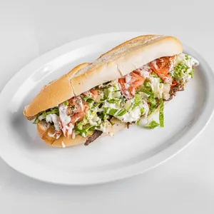 Steak baguette sandwich with mozzarella, provolone, caramelized onions, mushrooms, eggplant, lettuce and tomato