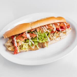 Veggie baguette sandwich with mozzarella, provolone, eggplant, roasted peppers, lettuce, tomato, and house dressing