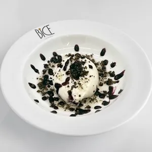 Burrata with blueberry jam, toasted pistachios and olive oil, a refined Italian cuisine appetizer