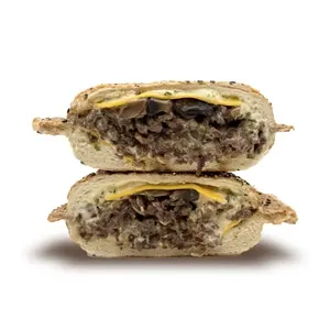 Steak Bombs sandwich on sesame panino bun with cheddar, house Bombe sauce, caramelized onions and mushrooms