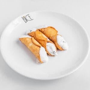 Mini cannoli filled with sweet ricotta and chocolate chips in crunchy shells, Italian cuisine dessert