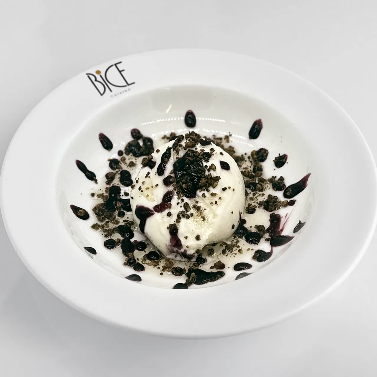 Burrata with blueberry jam, toasted pistachios and olive oil, a refined Italian cuisine appetizer