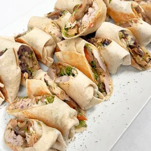 Warm mini wraps with tuna, melted provolone, mayo, caramelized onions, roasted peppers, lettuce and tomato