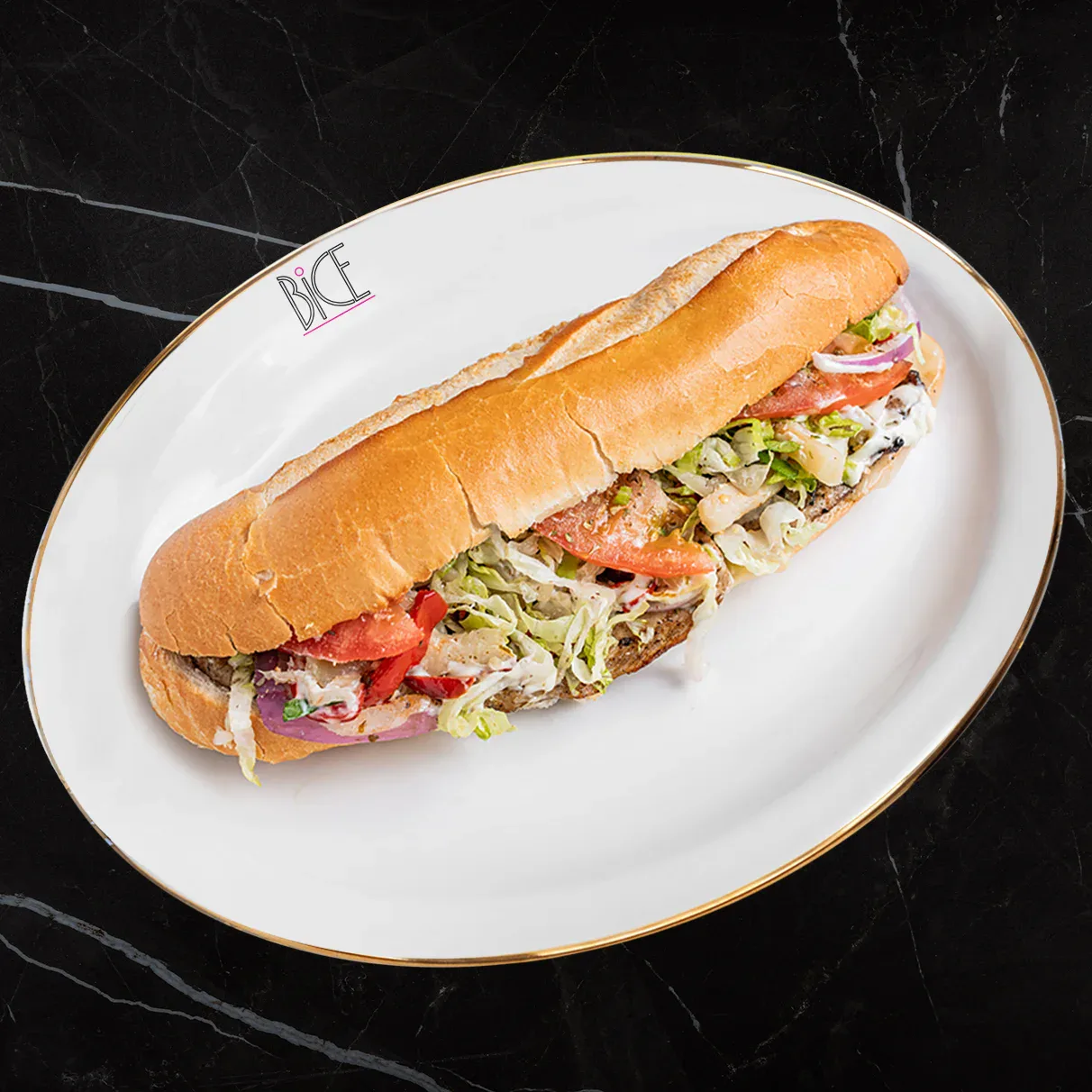 Baguette Steak Prosciutto Baguette Steak Prosciutto avec steak, prosciutto, fromages, légumes marinés et sauce maison de cuisine italienne
