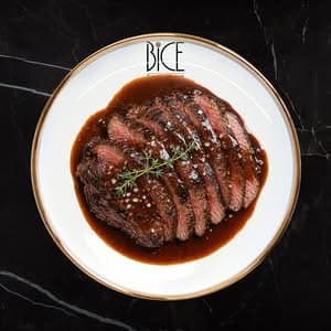 Bavette de bœuf juteuse nappée de sauce demi-glace, spécialité raffinée d’Italian cuisine