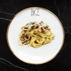 Pâtes carbonara nappées de demi-glace aux pleurotes, roquette fraîche et parmesan râpé