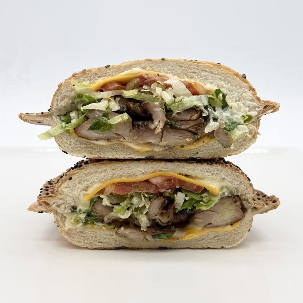 Poulet grillé en sandwich panino au sésame avec cheddar, mayo, laitue et tomate