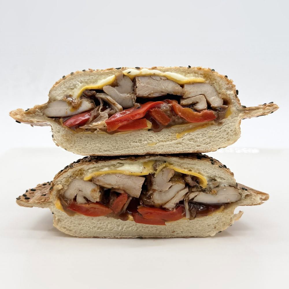 Panino au poulet grillé BBQ avec cheddar, mayo, oignons caramélisés et poivrons rôtis