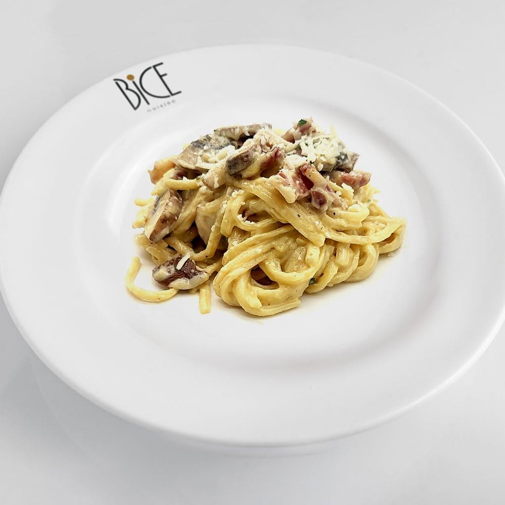 Rigatoni carbonara avec pancetta croustillante, champignons, parmesan, poivre noir et jaune d’œuf